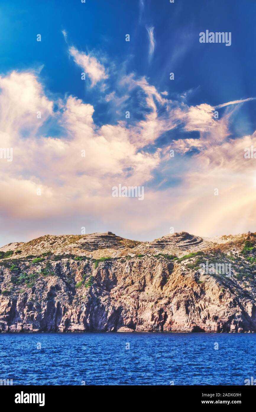 Vertical photo with view on Gyali island in Aegean see. Island is near famous Kos island. Sky is blue with dramatic sky. Piece of local mine is visibl Stock Photo