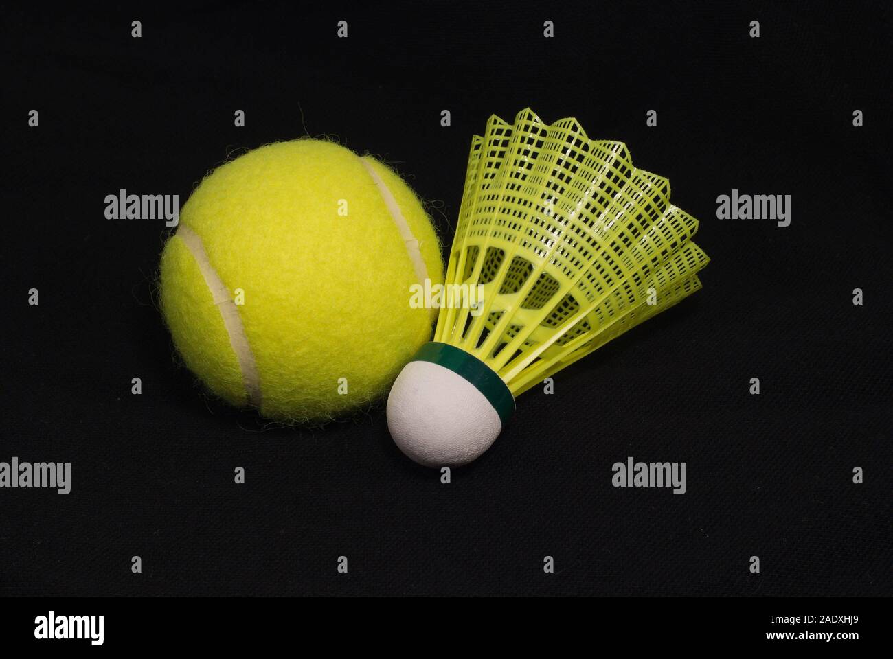 Yellow tennis ball and shuttlecock isolated on black Stock Photo