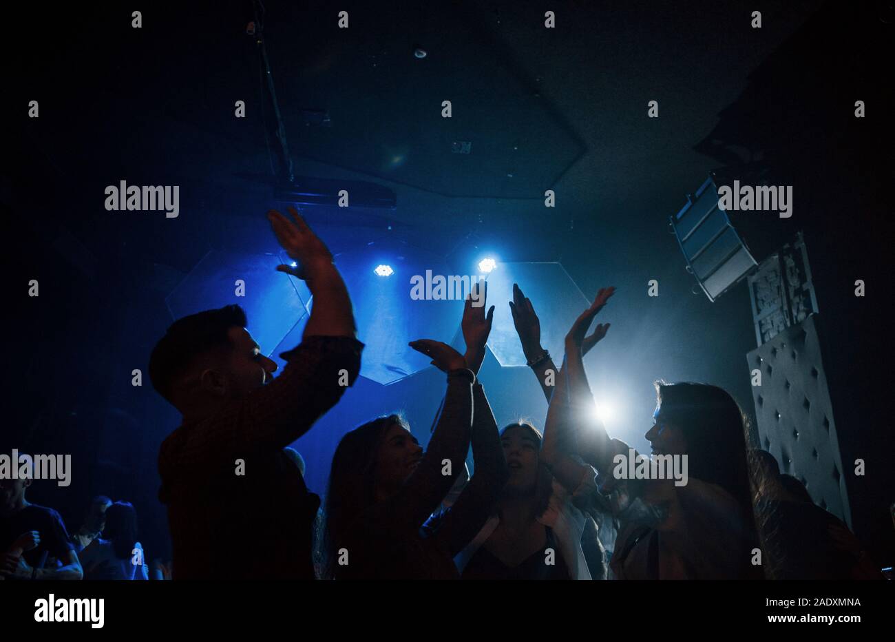 We are awesome. Group of people that enjoying dancing in the nightclub with beautiful lightings Stock Photo