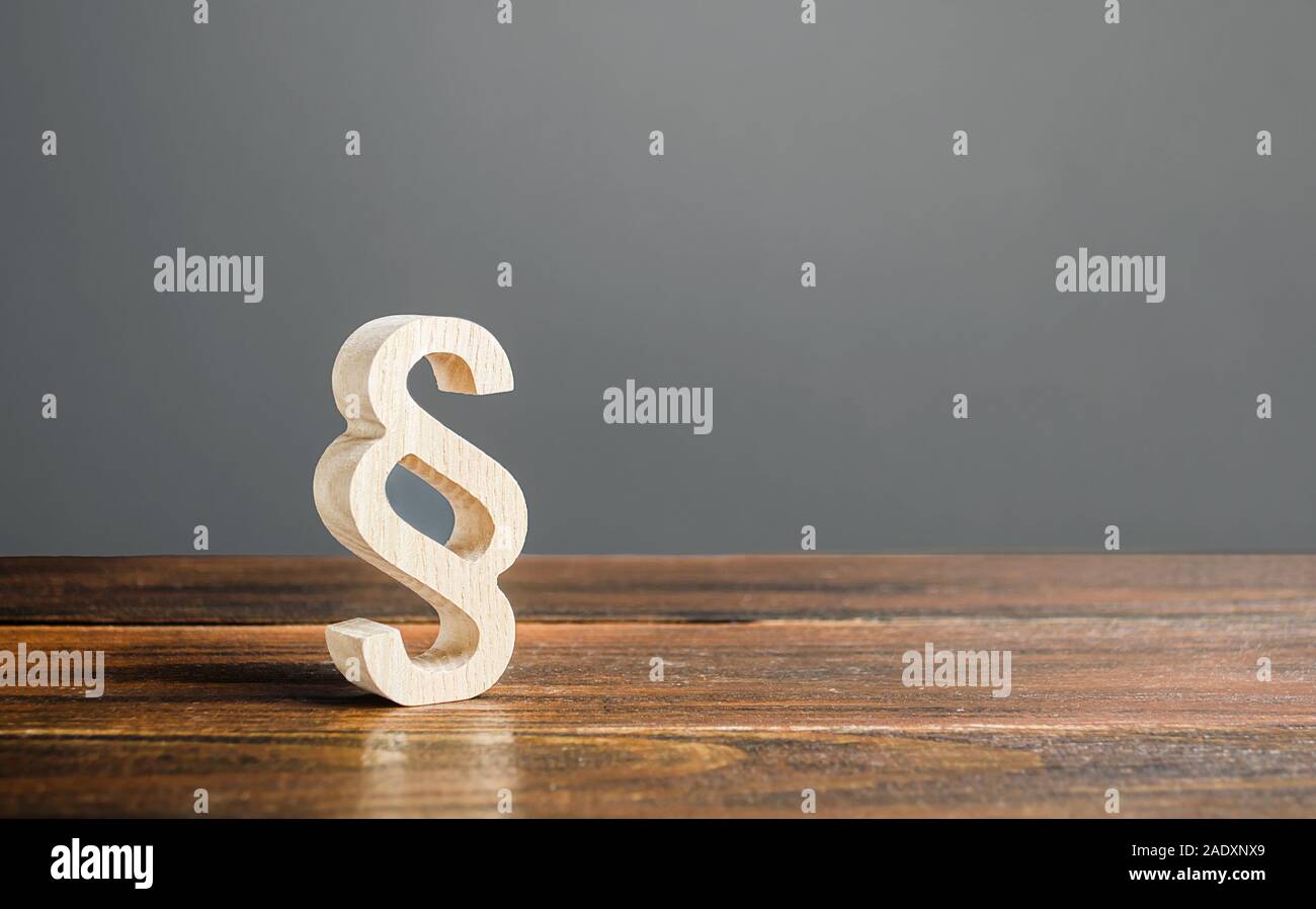 A wooden paragraph figurine. Democratic institutions, human rights and property. Legislation and lawmaking. Justice and judicial system concept. Legal Stock Photo