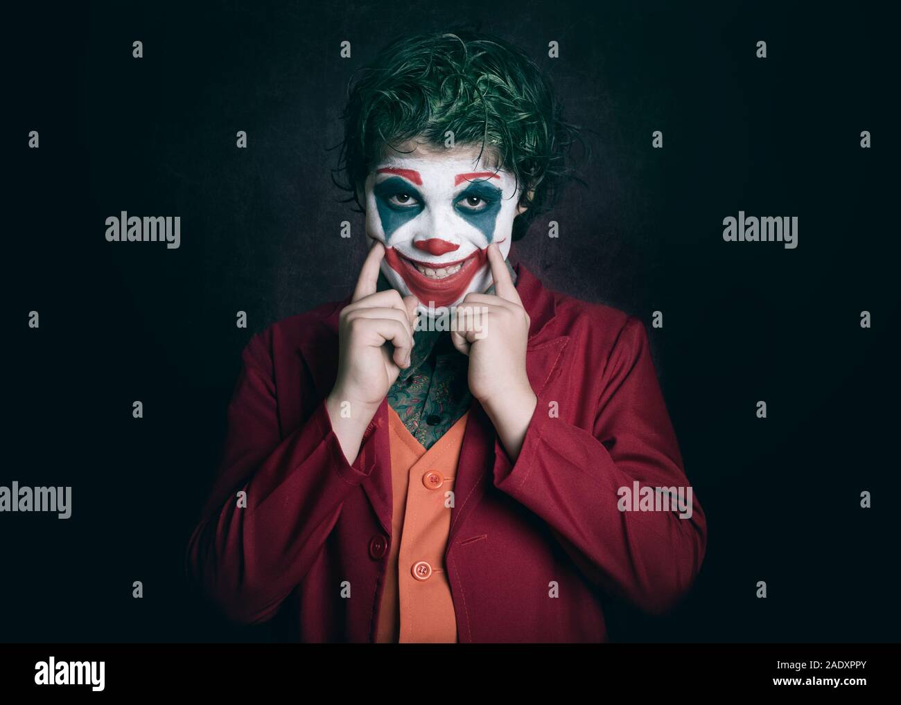 boy dressed as Joker on dark background Stock Photo
