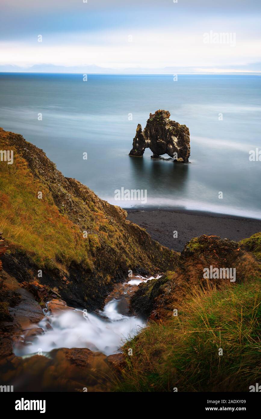 Hvitserkur basalt stack with a small waterfall in the foreground in northern Iceland. Hvitserkur is a spectacular rock in a shape of a dragon or dinos Stock Photo