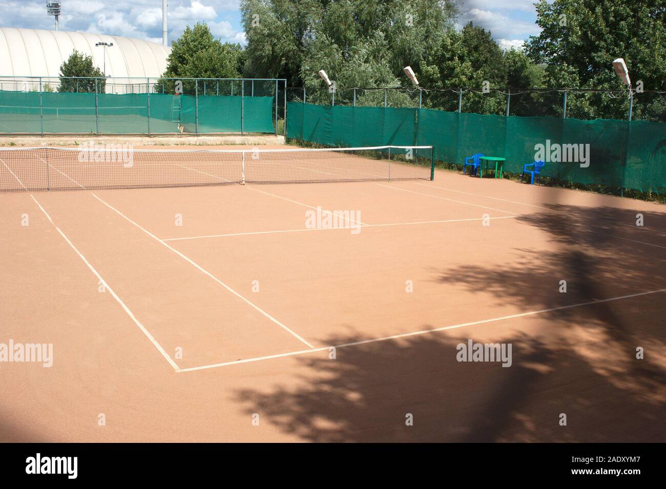Empty ground clay and sand tennis court surface with net in summer day  outdoors Stock Photo - Alamy, image size:1300x955