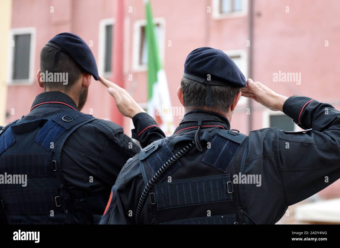 Italian soldiers saluting flag of Italy. Carabinieri saluting Italian flag. Italian Armed Forces Stock Photo