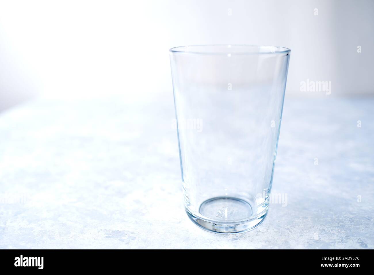Empty glass isolated on a blue background close up Stock Photo