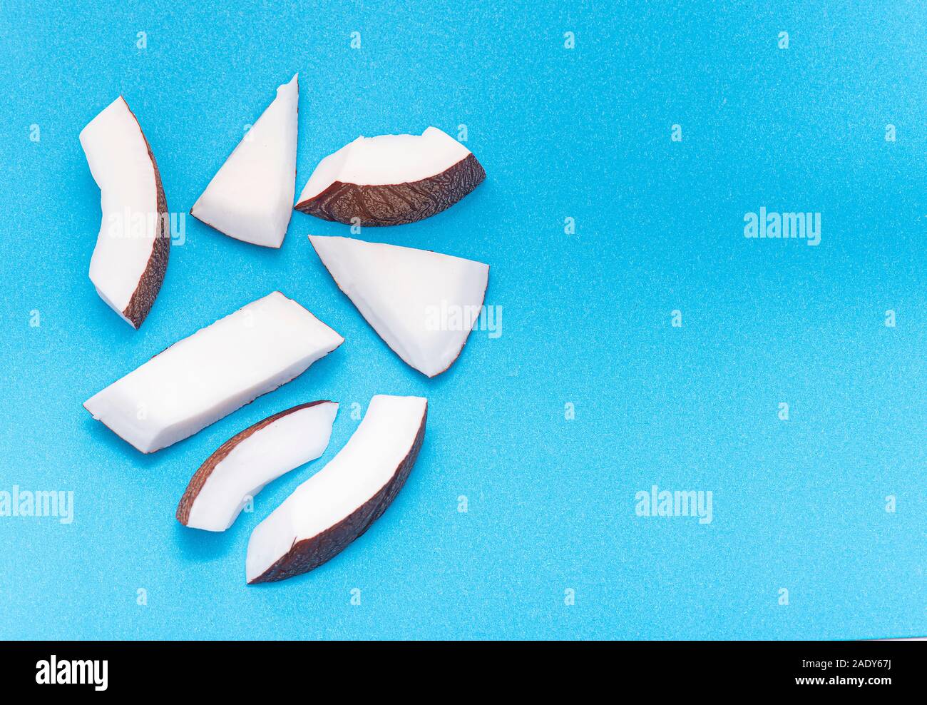Coconut Pieces, Cut Coconut isolated on colored Background Stock Photo