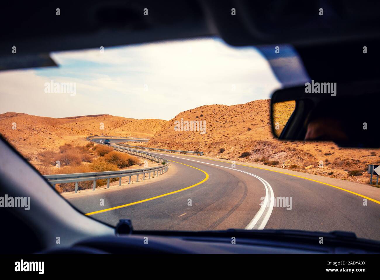 Driving a car on the mountain road in the desert. View of sandstone ...