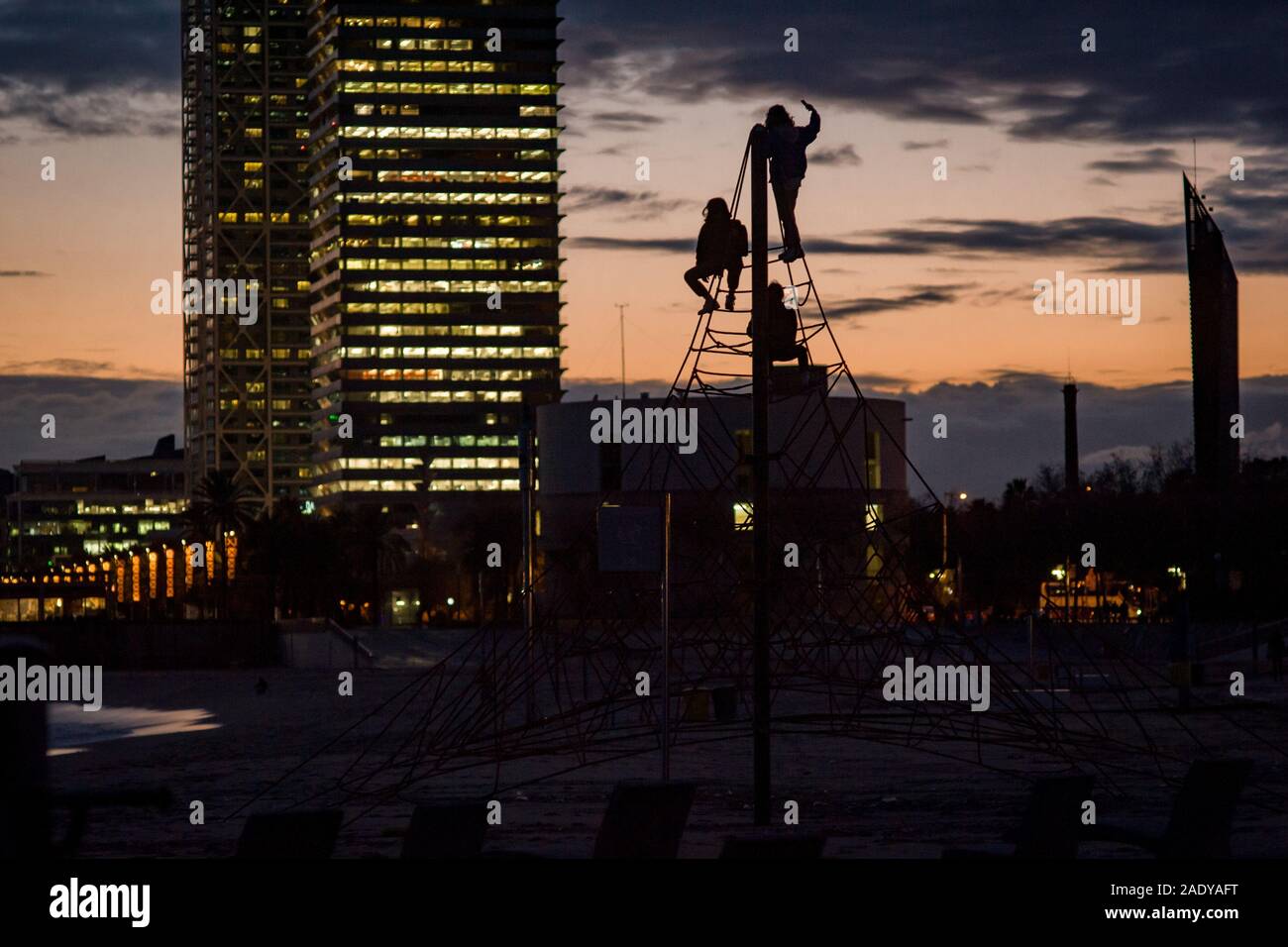 Barcelona, Spain. 05th Dec, 2019. People is seen silhouetted at the top of an urban swing as the sun sets after a stormy day in Barcelona. DANA or cold drop is weather phenomenon often occurring in autumn and that brings strong and harmful storms at the Spanish east coast area. Credit: Jordi Boixareu/Alamy Live News Stock Photo