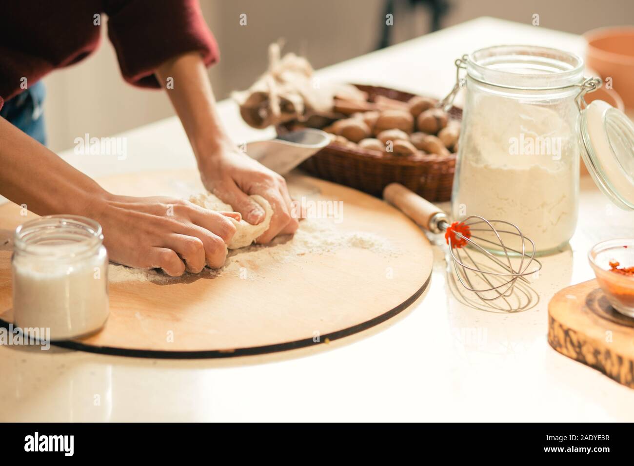 Female cook kneading dough on the table Stock Photo