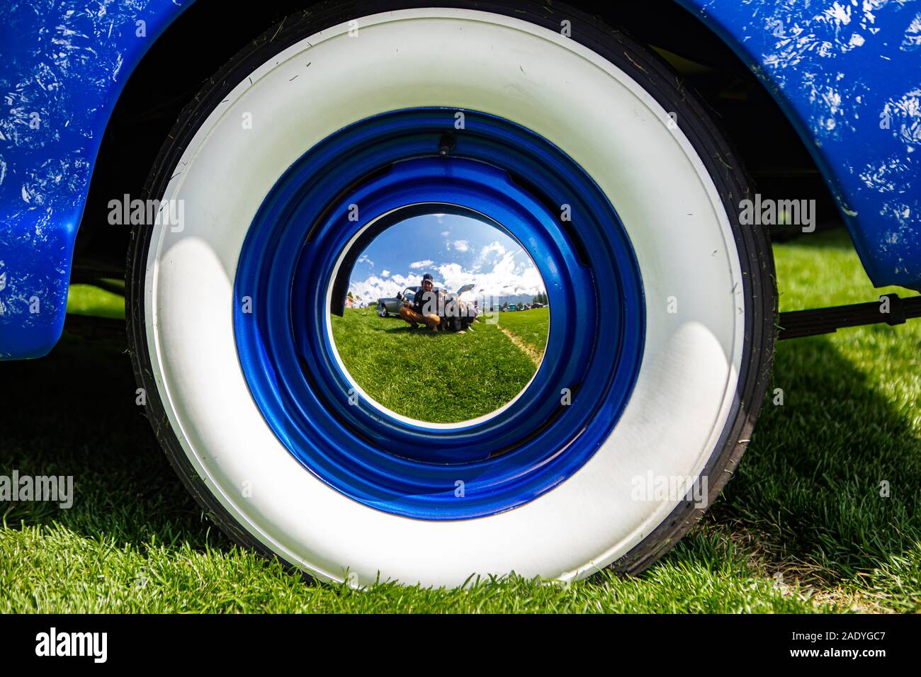 vintage classic American bright blue car wheels on the grass, Close up on the Steel Wheel Chrome center and Whitewall tire Stock Photo