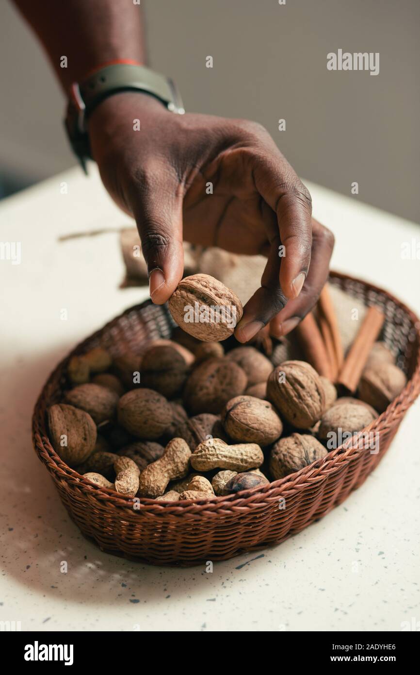 Peanuts and walnuts in wicker basket on the table Stock Photo