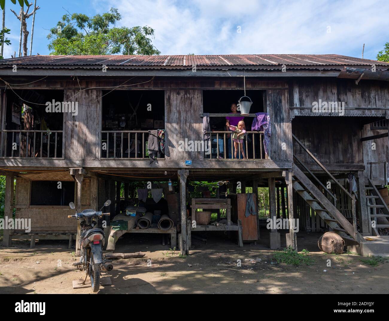 A traditional Burmese village house with tin roof, wooden construction, raised pilings and open air outlook in northwestern Myanmar (Burma) Stock Photo