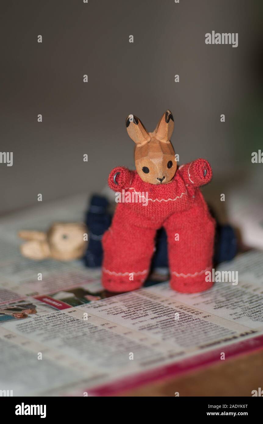 Rag-wooden bunnies, analogue toys on the background of the newspaper Stock Photo