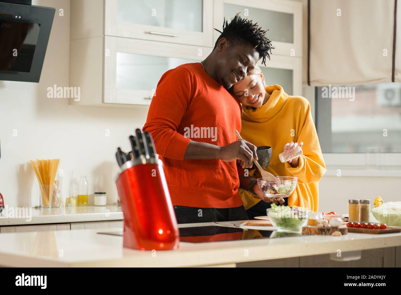 Smiling lady putting head on the shoulder of her boyfriend while cooking Stock Photo Alamy