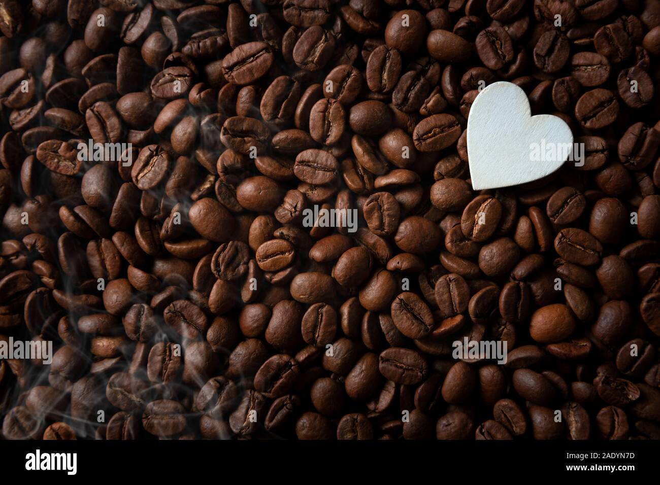 Coffee beans with white hearts, with smoke and copy space Stock Photo