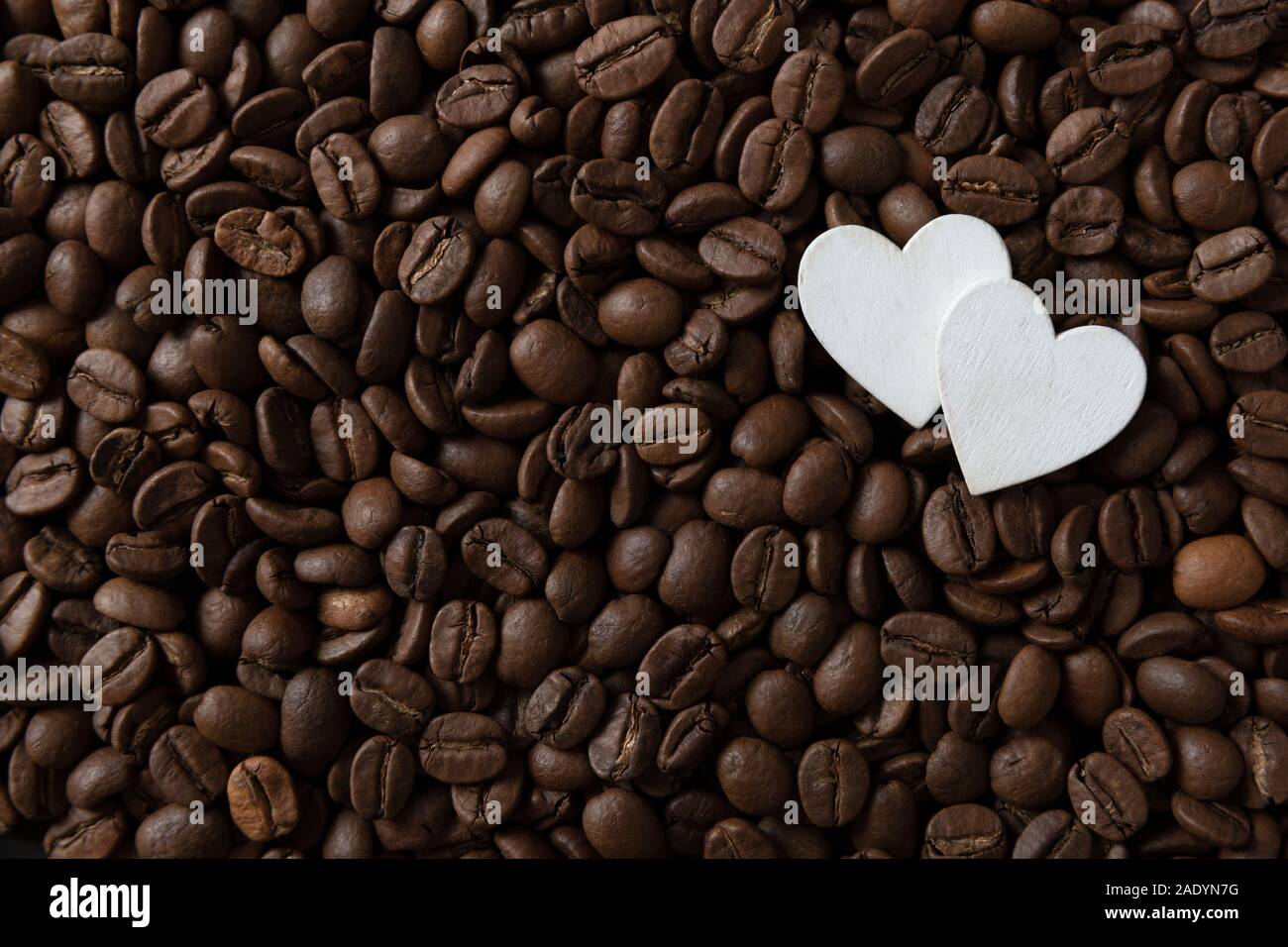 Coffee beans with white hearts, with smoke and copy space Stock Photo