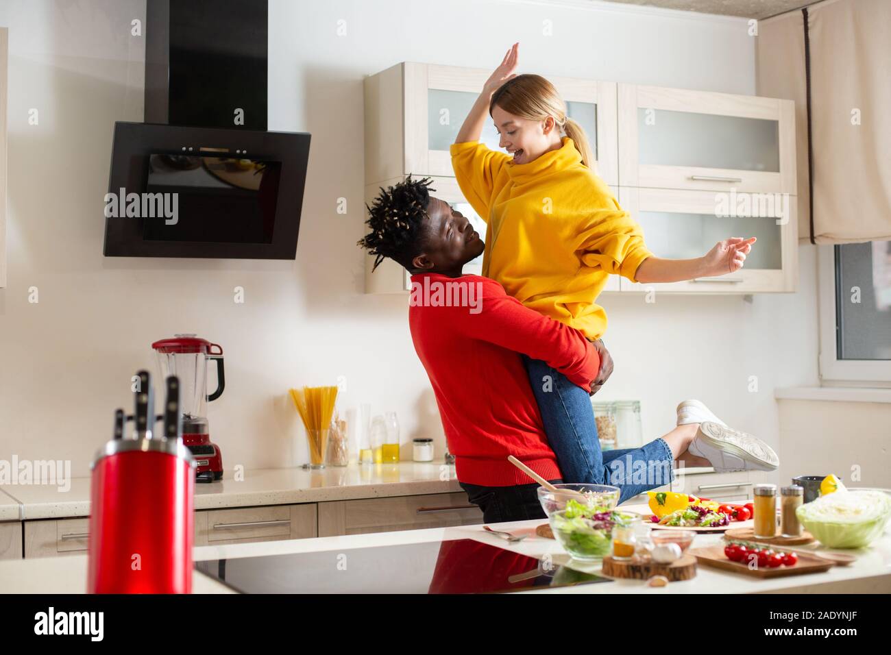 Excited lady smiling while being in arms of her loving boyfriend Stock Photo