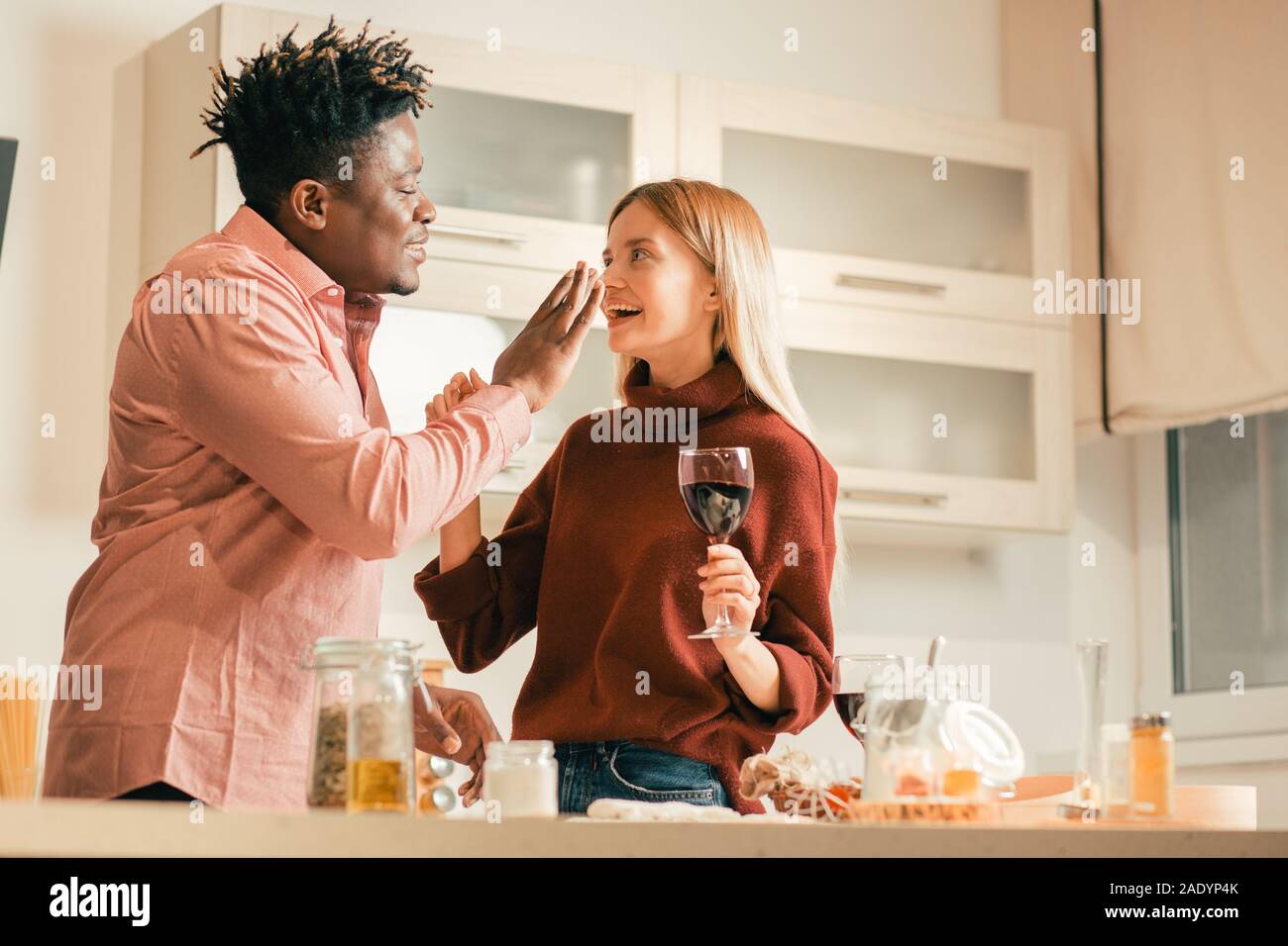 Careful man putting flour spot on the nose of laughing lady Stock Photo