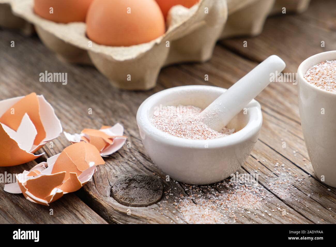 Mortar of crushed eggshell,cardboard box of eggs. Whole and powdered