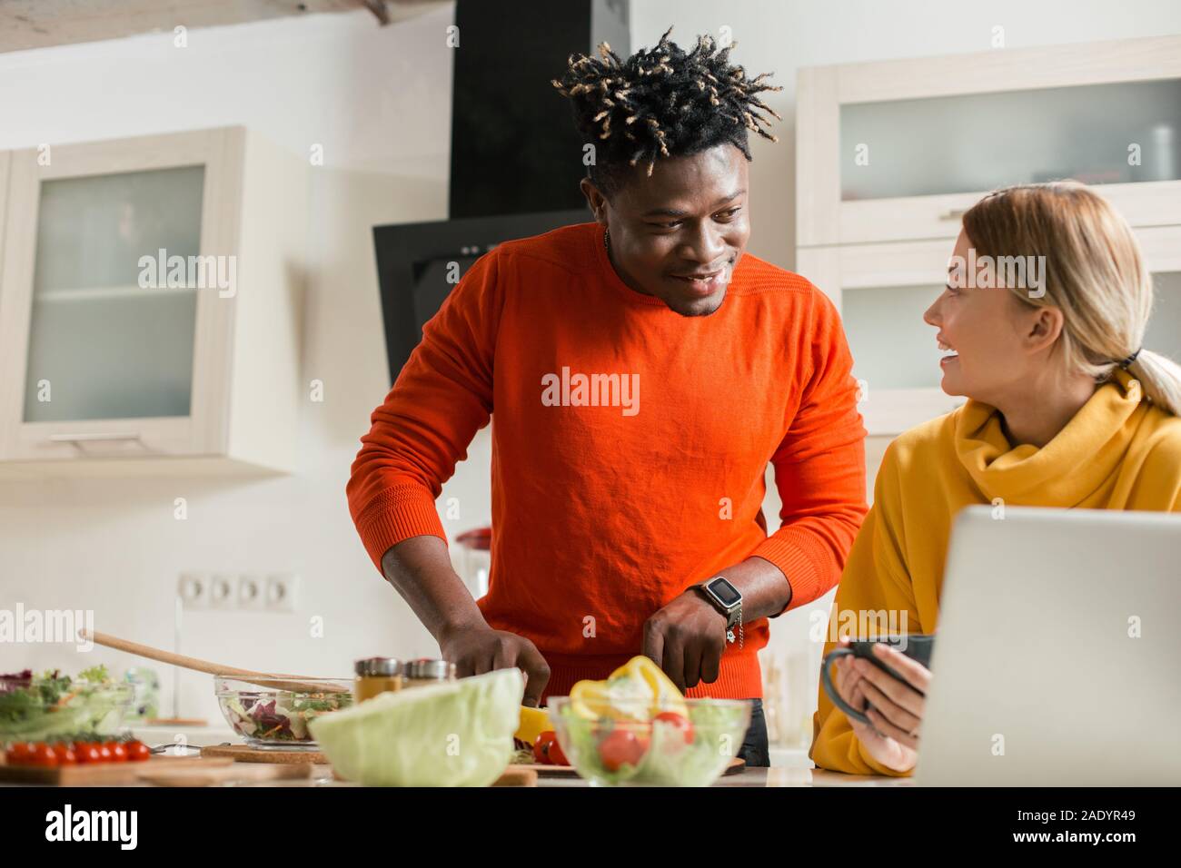 Man cooking and his smiling girlfriend looking at him Stock Photo