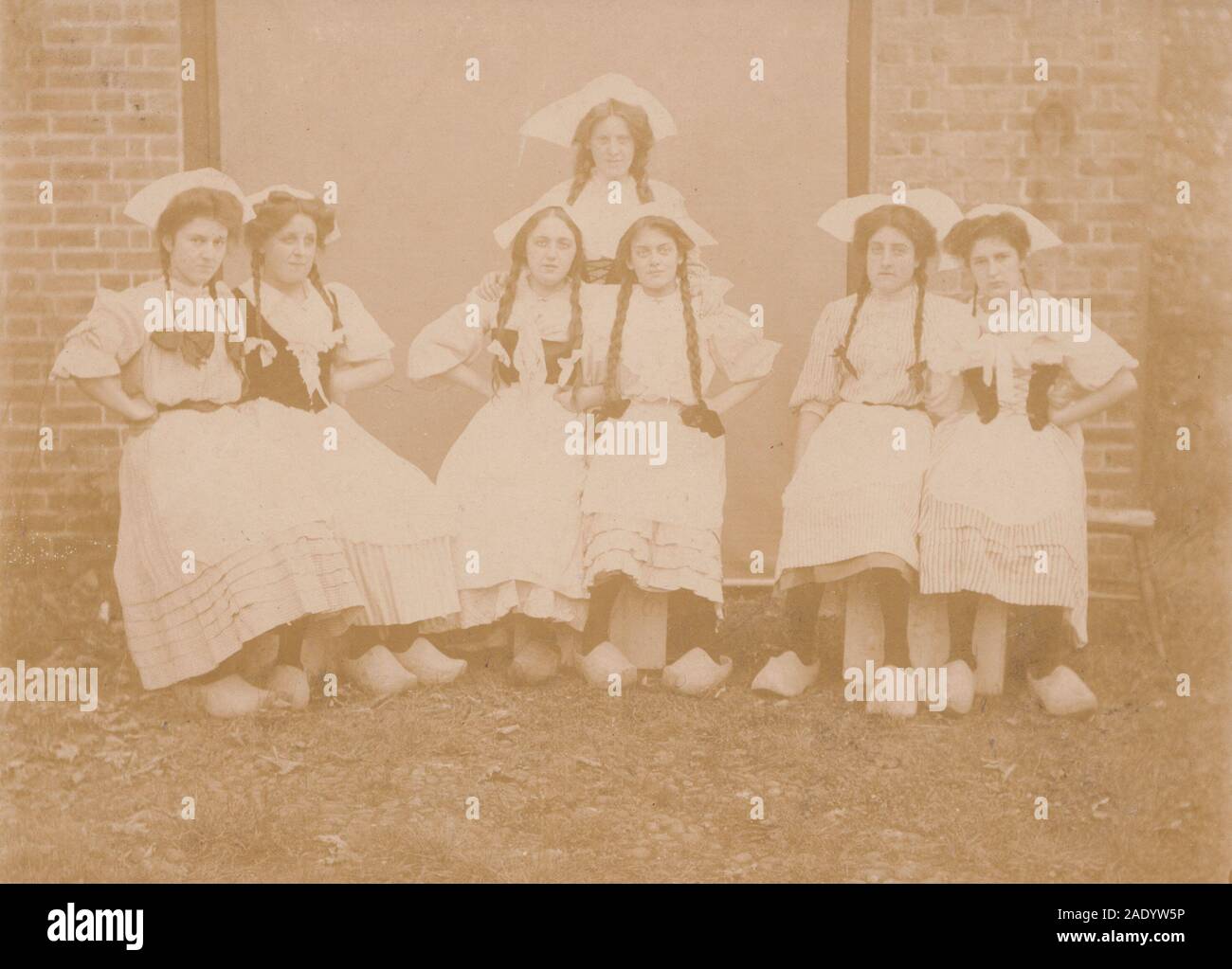 Vintage Early 20th Century Photographic Postcard Showing Seven Girls Dressed up in Dutch Costumes. Stock Photo