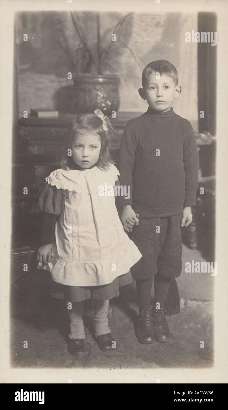 Vintage Early 20th Century Photographic Postcard Showing a Brother and Sister Holding Hands Stock Photo