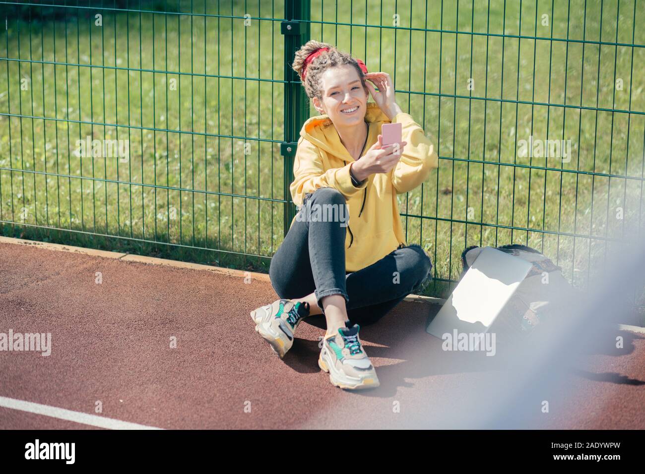 Happy lady smiling while sitting at the sports ground alone Stock Photo