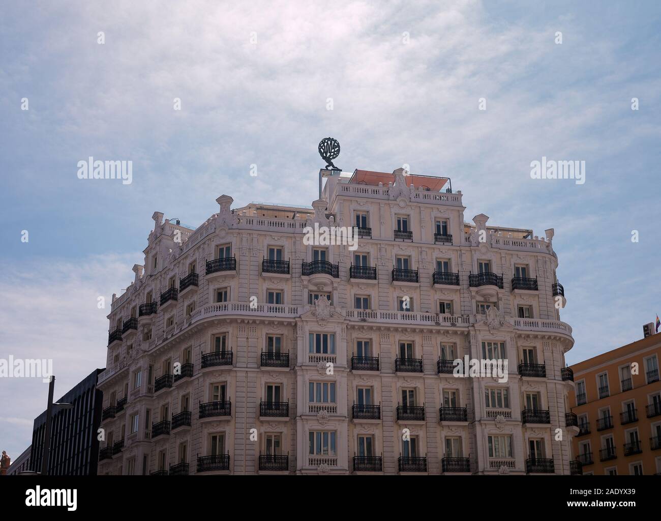 Madrid, Spain - JUL 22 2019: Beautiful white building against blue sky at Calle Gran Via. Backlit image. Stock Photo