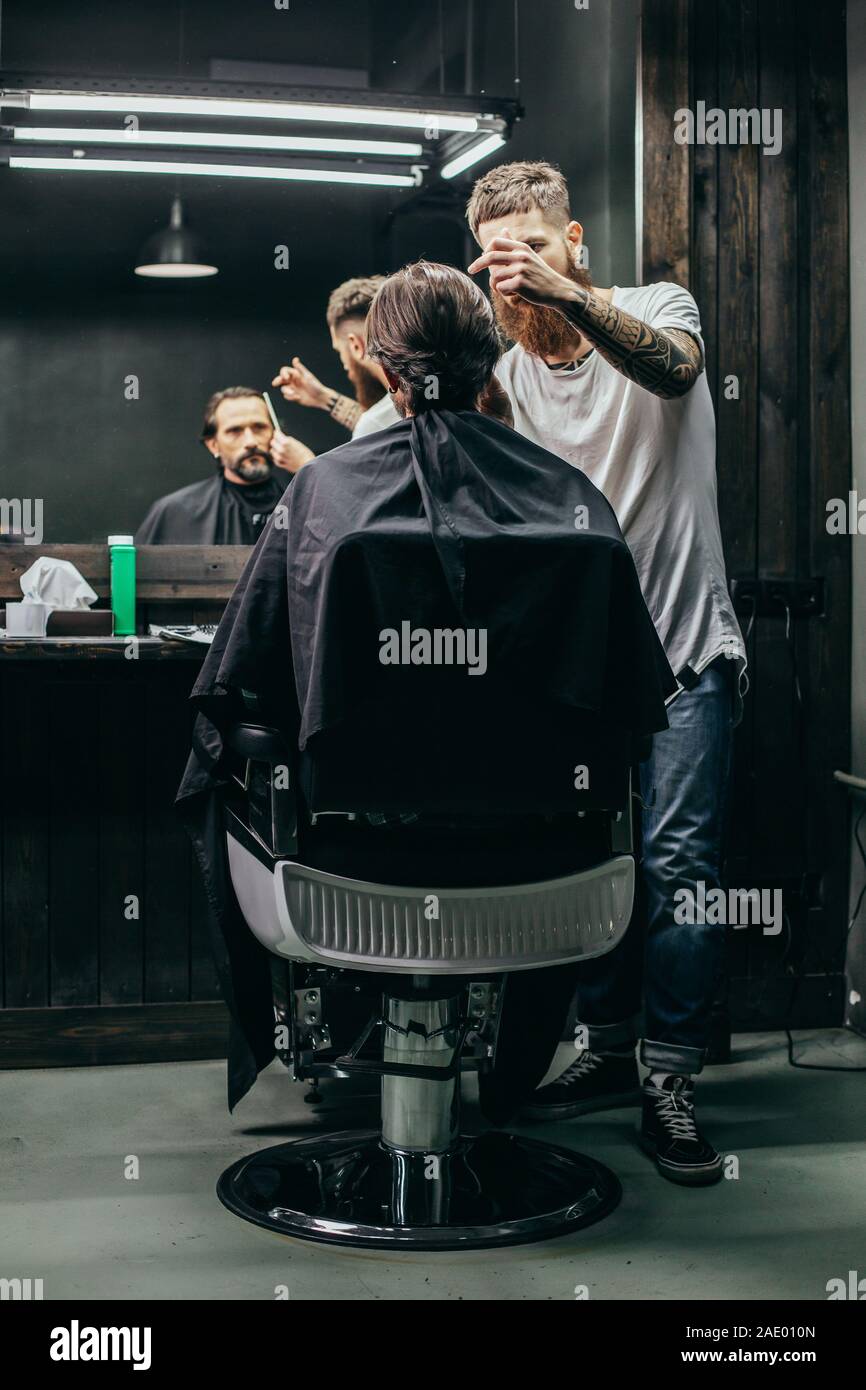 client looking at his reflection while barber working Stock Photo Alamy
