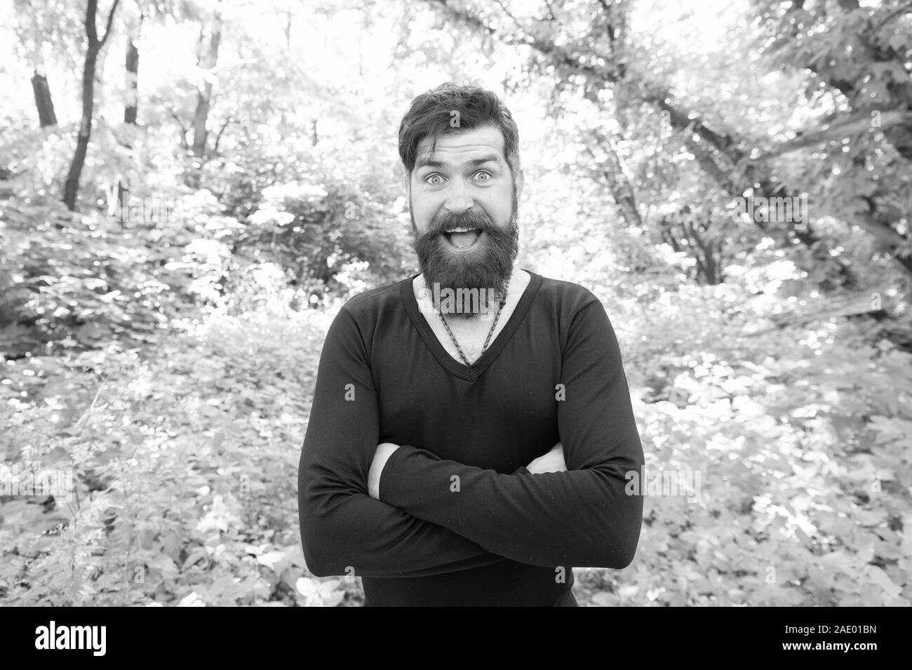 Exploring nature. Handsome man with beard and mustache in nature. Brutality of jungles concept. Summer heat season. Wild nature. Man bearded hipster bright foliage background. Guy relax in forest. Stock Photo
