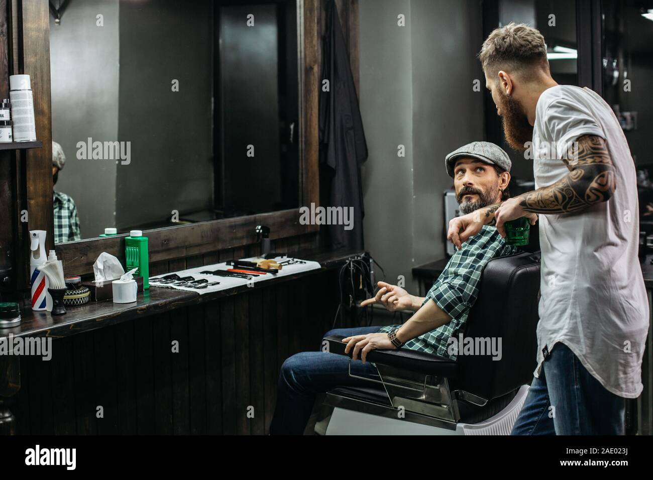 Calm man turning to his barber and asking questions Stock Photo Alamy