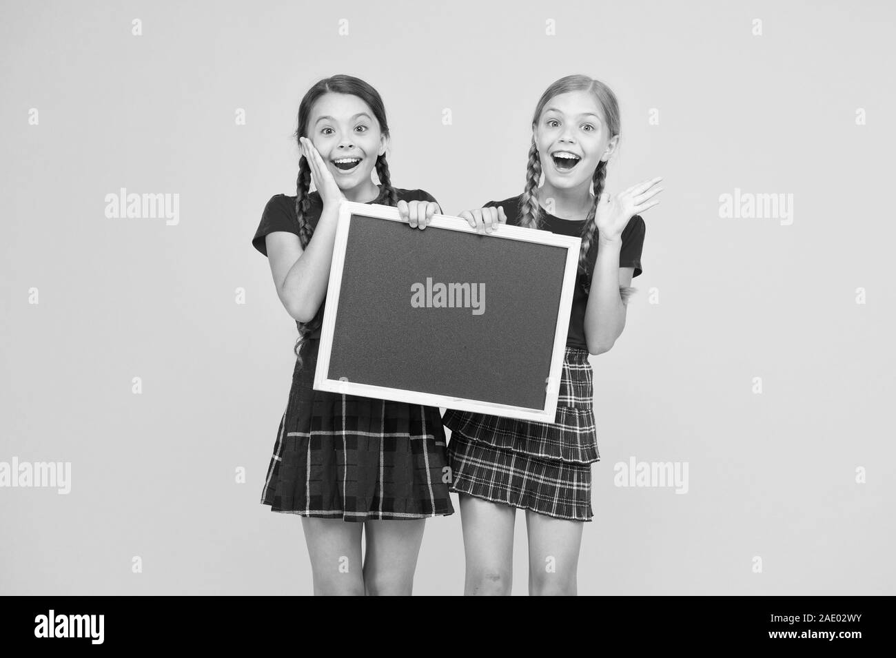 what a great news. children presenting bulletin board. big sales. happy small girls with blackboard. place for announcement. information office. school project presentation. copy space. Stock Photo