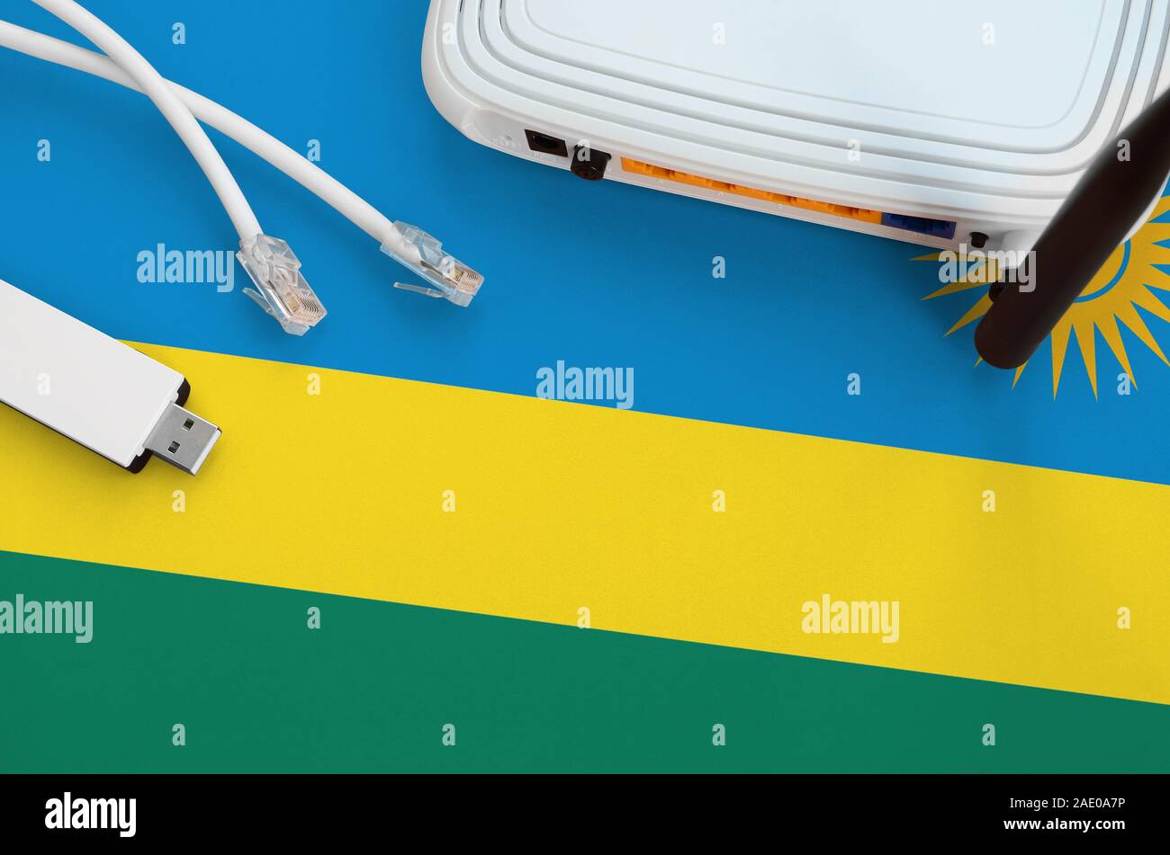 Rwanda flag depicted on table with internet rj45 cable, wireless usb wi ...