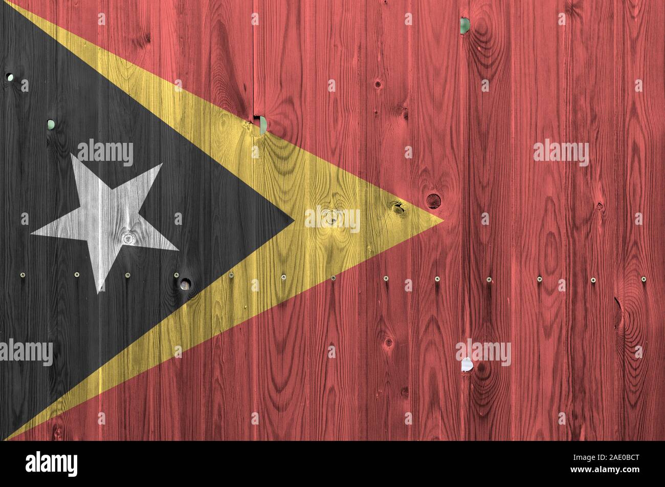 Timor Leste flag depicted in bright paint colors on old wooden wall