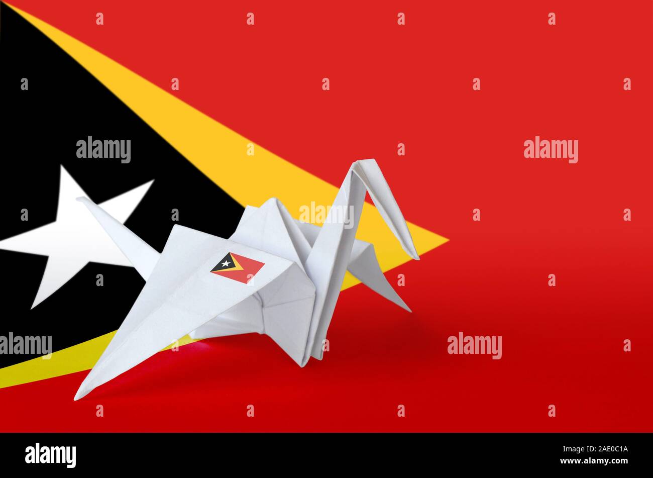 Timor Leste flag depicted on paper origami crane wing. Oriental handmade arts concept Stock Photo