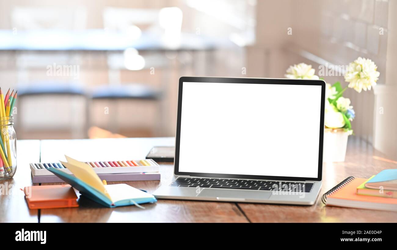 Mockup laptop computer isolated white screen on creative workspace ...