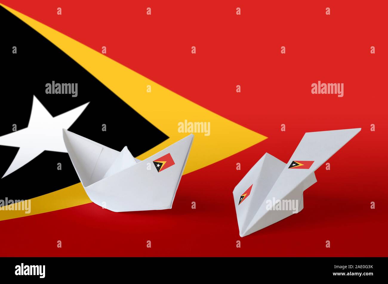 Timor Leste flag depicted on paper origami airplane and boat. Oriental handmade arts concept Stock Photo