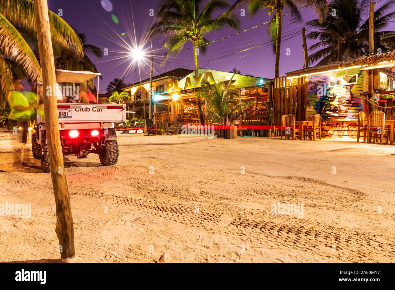 San Pedro, Ambergris Caye, Belize - November, 17, 2019. A street view of bright restaurants on Ambergris Caye island beach at night. Stock Photo