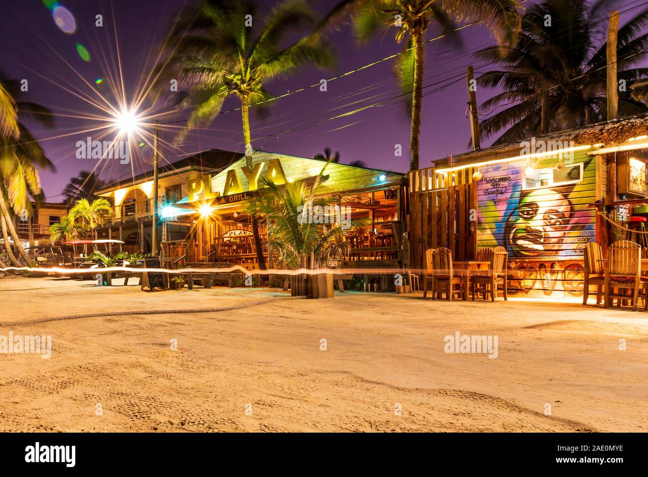San Pedro, Ambergris Caye, Belize - November, 17, 2019. A street view of bright restaurants on Ambergris Caye island beach at night. Stock Photo