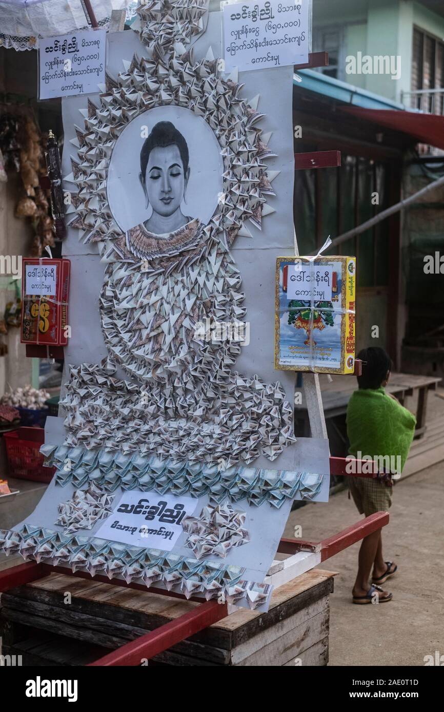 An ornate float as a donation consisting of folded currency and an image of the Buddha in a parade honoring the village monks in rural Myanmar (Burma) Stock Photo