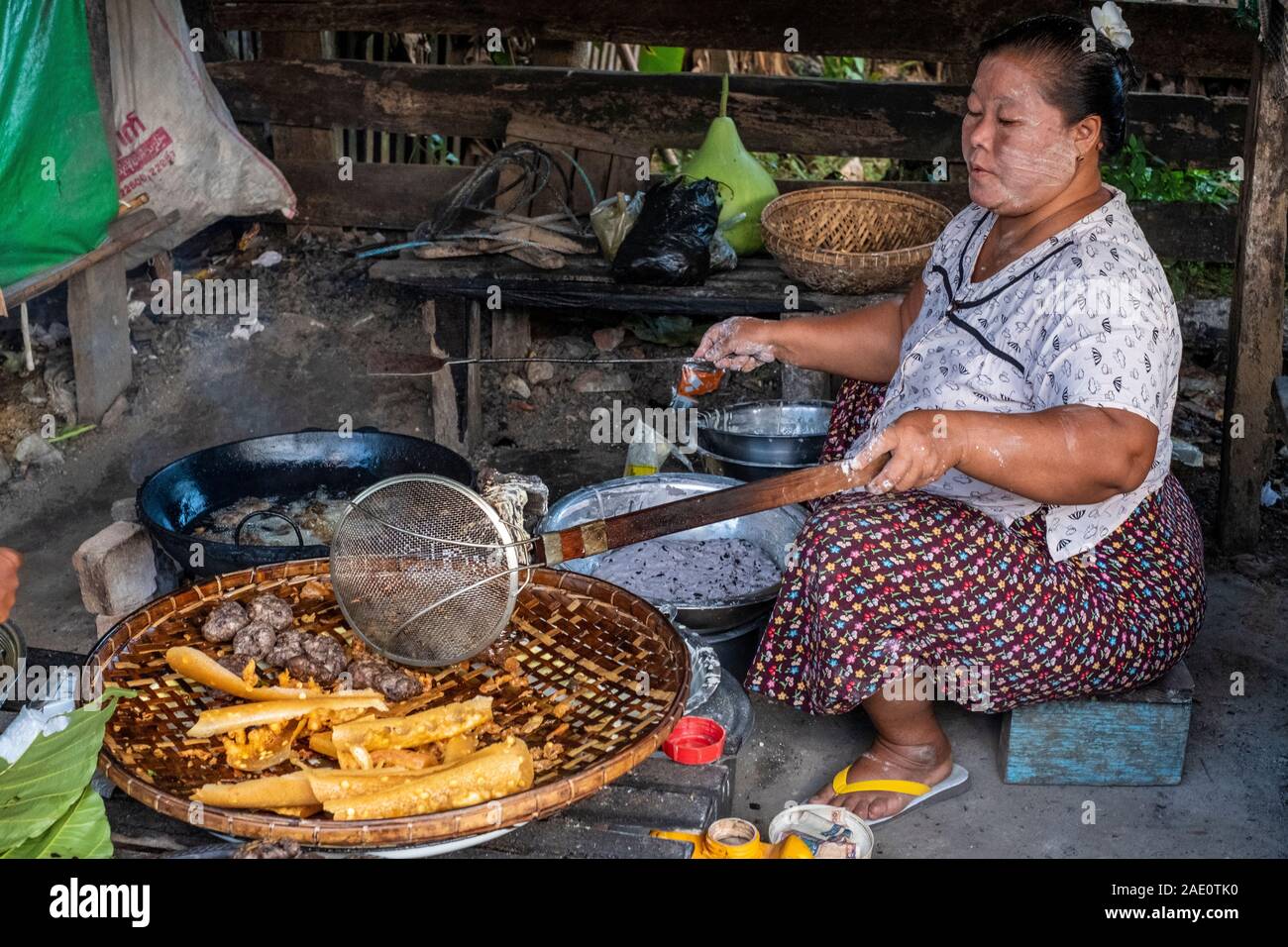 Large village woman fries local culinary delicacies for sale in a marketplace in Kanne village along the Chindwin River in rural Myanmar (Burma) Stock Photo