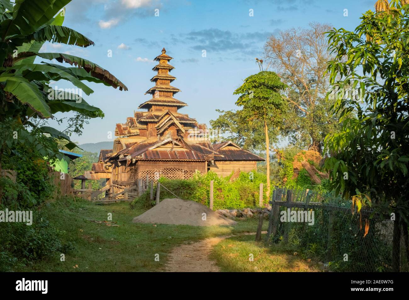 A beautiful architectural temple made of wood at the base of a footpath in a remote village in northwestern Myanmar (Burma) Stock Photo