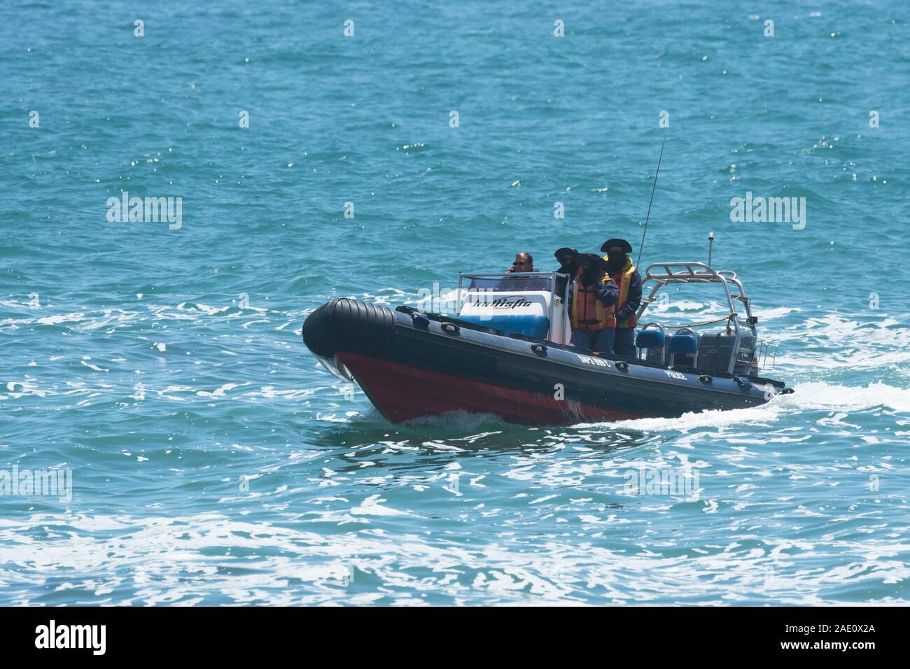 South African police dive unit in an inflatable rubber dingy boat during a patrol search and rescue operation for missing people in Cape Town Stock Photo