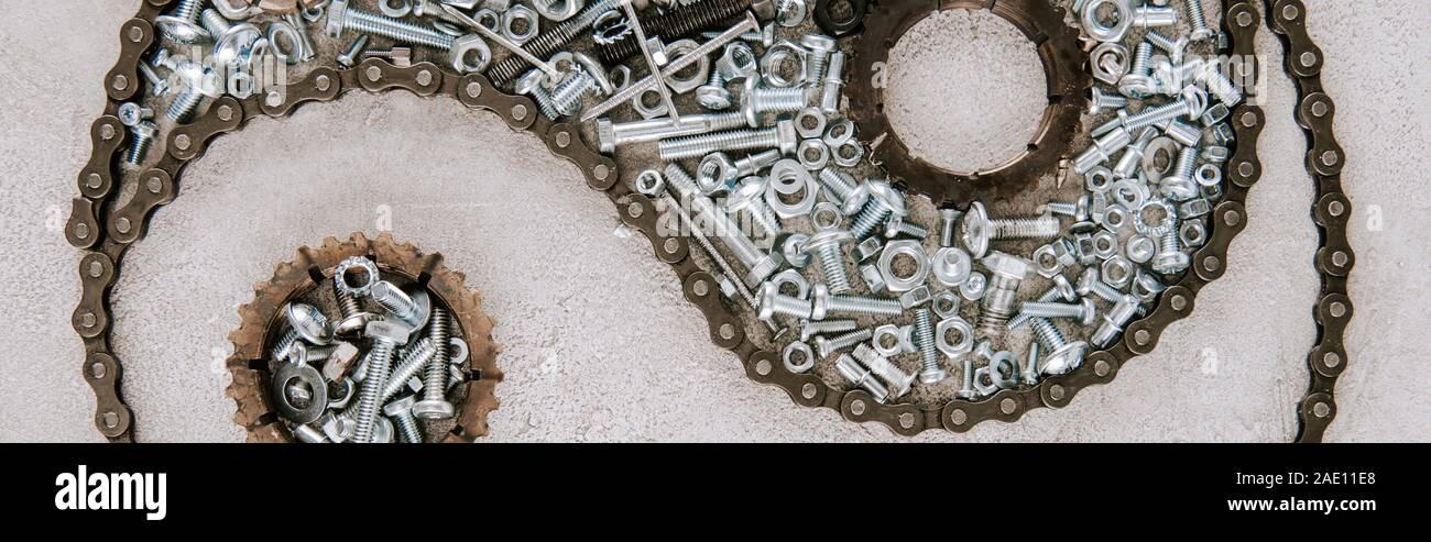 top view of aged metal gears and screws arranged in taijitu symbol on grey background, panoramic shot Stock Photo