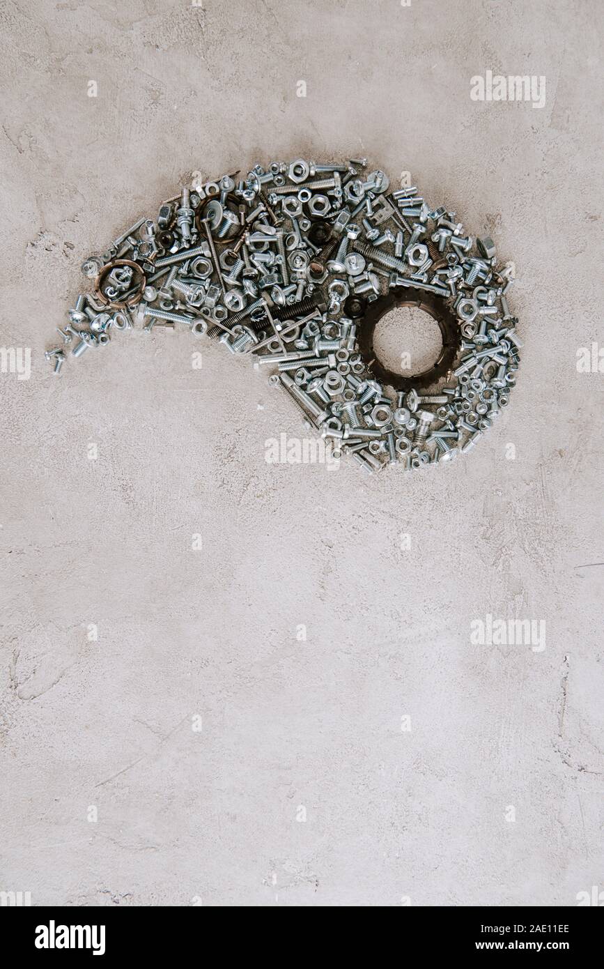 top view of aged metal screws arranged in part of taijitu symbol on grey background Stock Photo