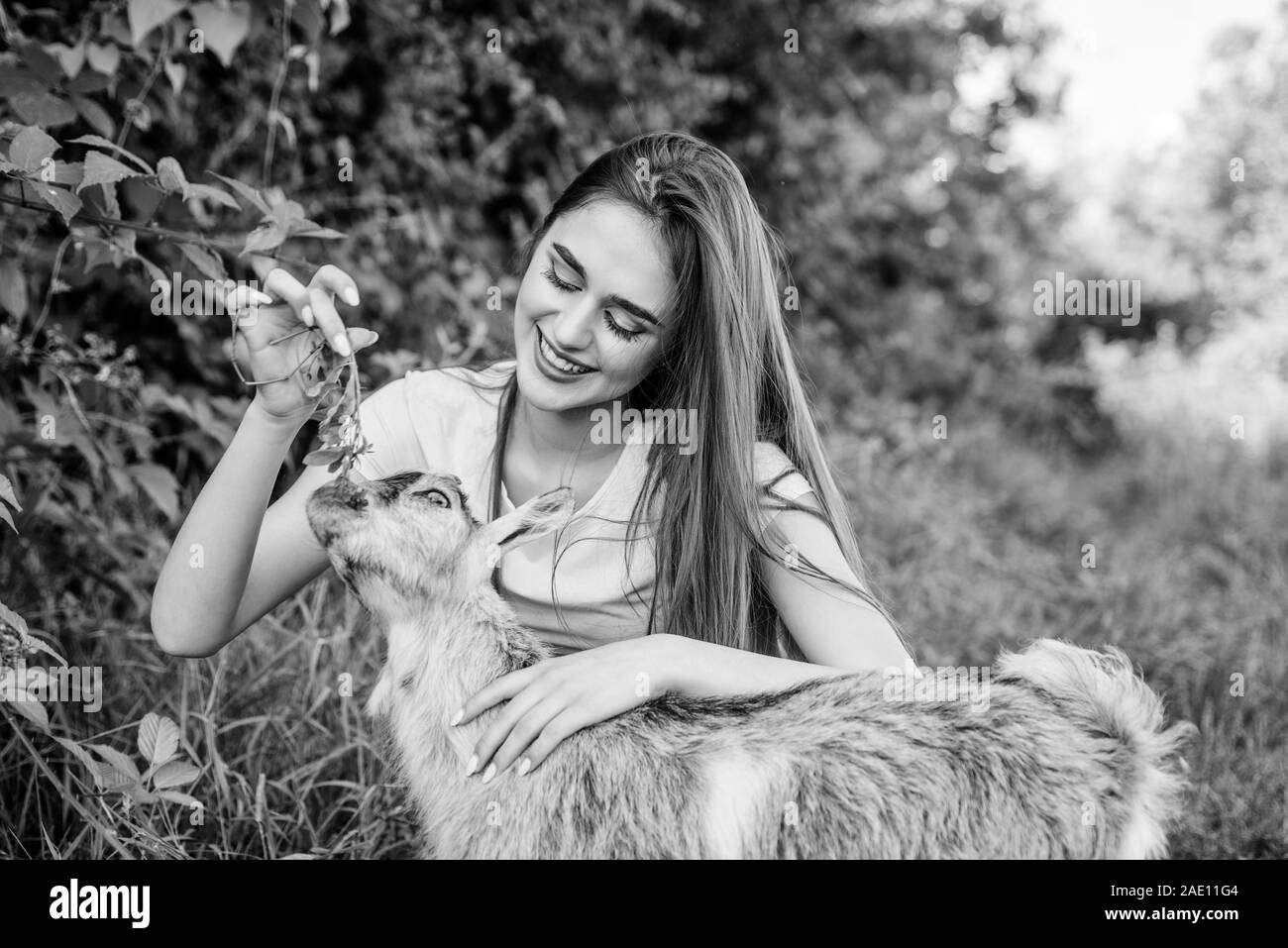 Woman and small goat green grass. Veterinarian occupation. Eco farm