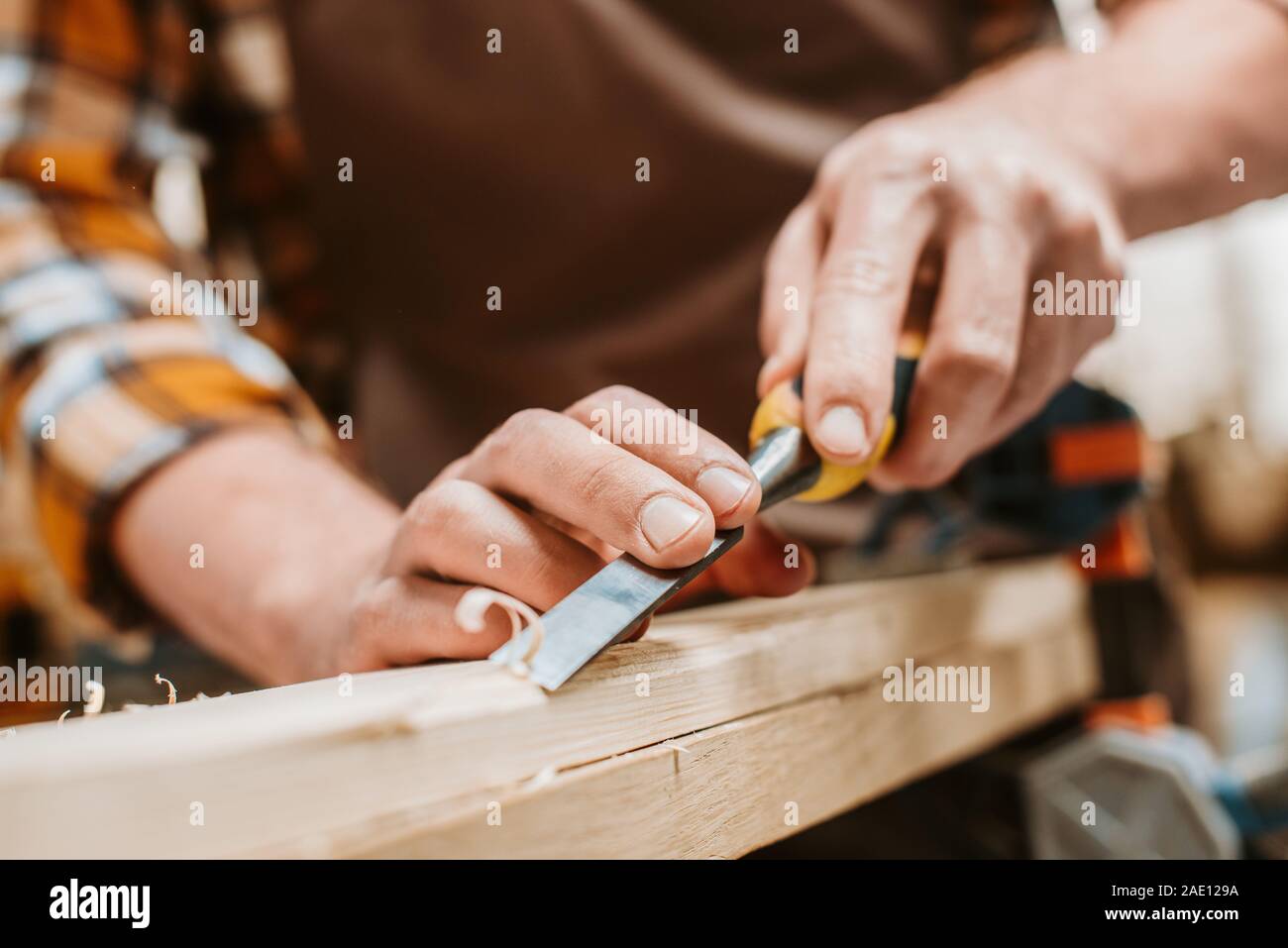 cropped view of carpenter carving wood on workshop Stock Photo