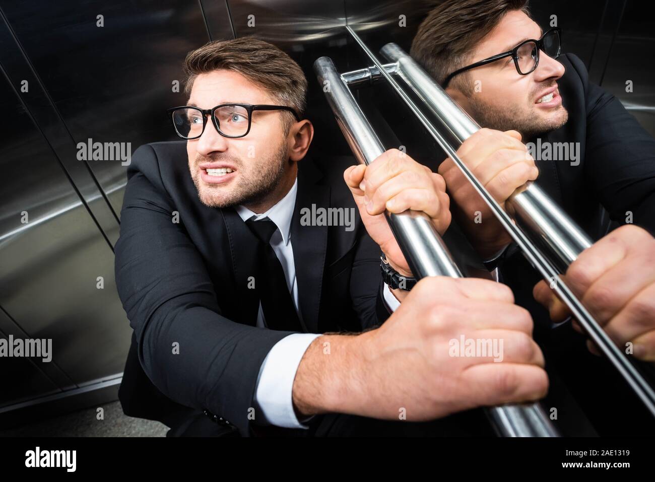 high angle view of scared businessman in suit with claustrophobia in elevator Stock Photo