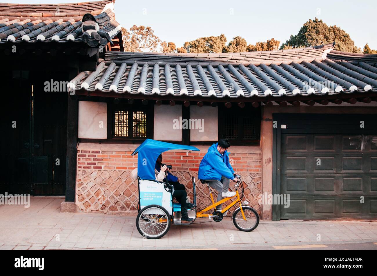 DEC 13, 2016 Seoul, South Korea - Tourists and Pedicap rickshaw tour in beautiful vintage Bukchon Hanok old local village. Stock Photo