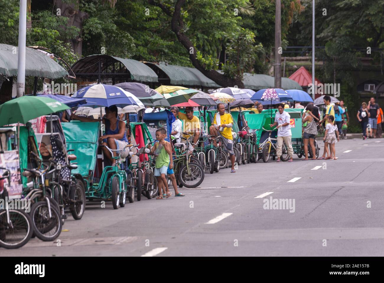 Manila, Philippines - August 23, 2017: Many philippine tricycles with drivers in road street Stock Photo
